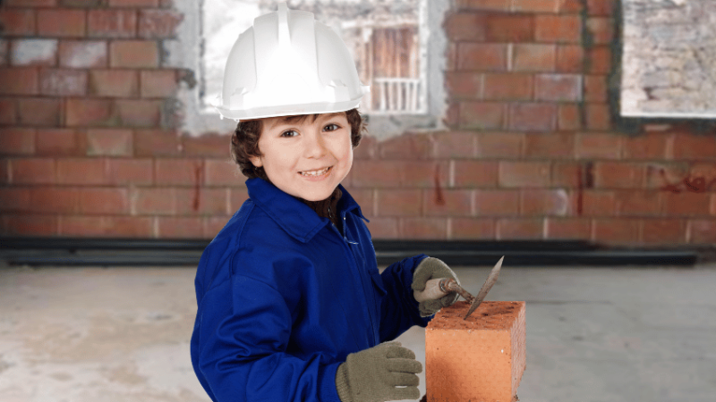 Young child trying bricklaying, representing firsthand experiences