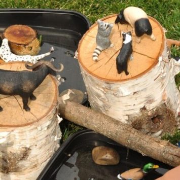 Reggio Emilia approach activity idea involving wooden logs and toy animals