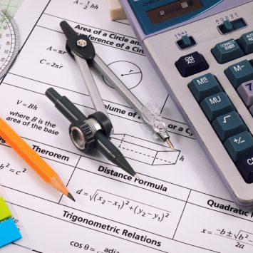 Maths equipment on top of Key Stage 3 maths worksheets