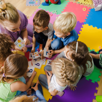 Children in a circle with teacher, representing behaviour management in early years