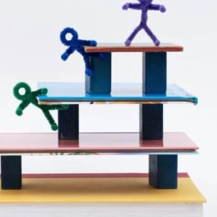 Pipe cleaner figures walking up steps, representing curriculum sequencing