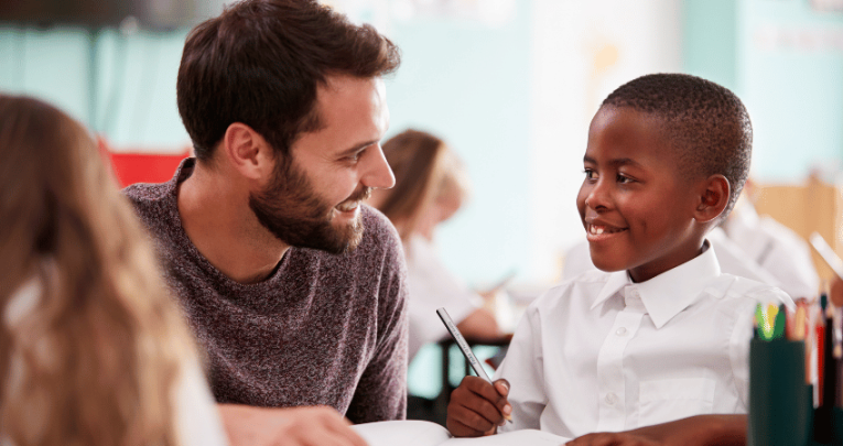 Schoolboy with Developmental Language Disorder smiling at teacher