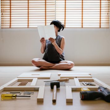 Woman looking at flatpack furniture instructions, representing instructional writing