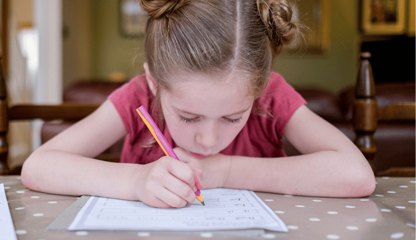 Girl practising handwriting, representing the idea of teaching handwriting in school