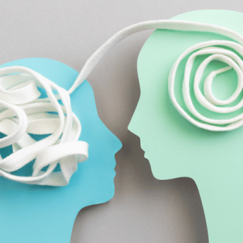 Two paper heads, linked together by white shoelace, representing relationships and sex education