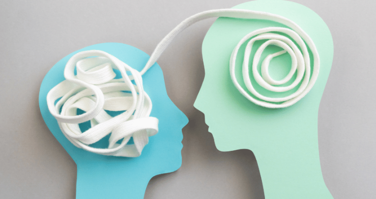 Two paper heads, linked together by white shoelace, representing relationships and sex education