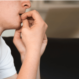 Anxious boy in school uniform biting nails, representing EBSA