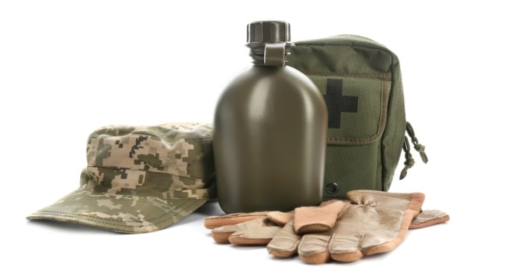 isolated photo of army equipment, including khaki cap, flask, first aid kit and gloves