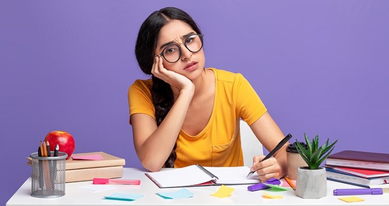 Photo of girl studying at desk, looking anxious