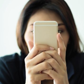 Photo of woman using a smartphone with her face conceal to illustrate notion of parental complaints