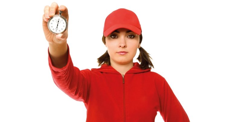 Young female sports teacher holding up a stopwatch, representing coaching models