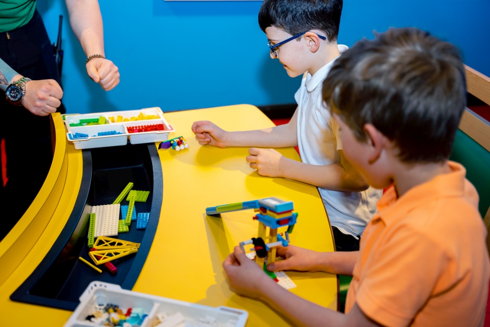 Two primary school boys choosing LEGO bricks at a LEGOLAND Discovery Centre workshop 