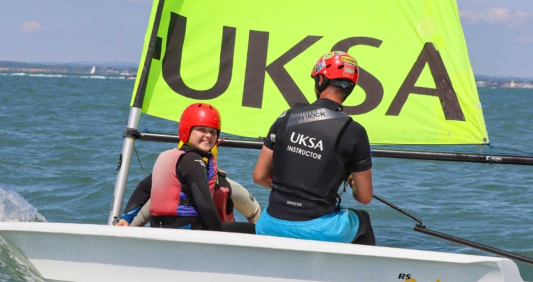 A primary school girl in a sailing boat with a UKSA instructor