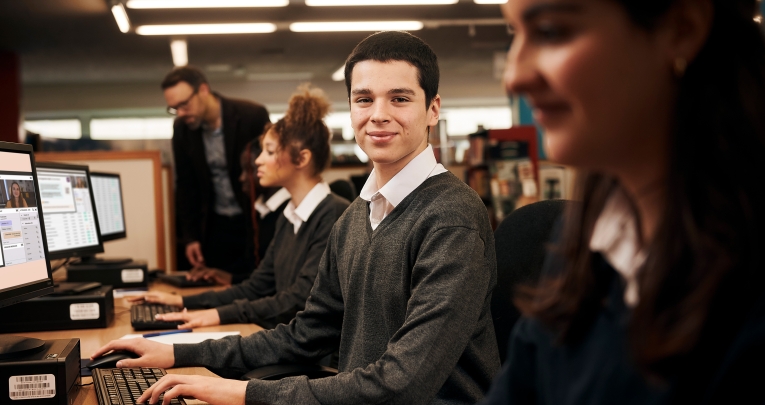 A schoolboy typing on a computer keyboard