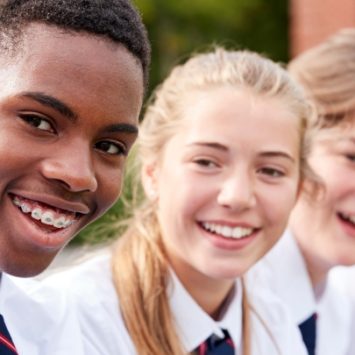 A group of smiling secondary school children