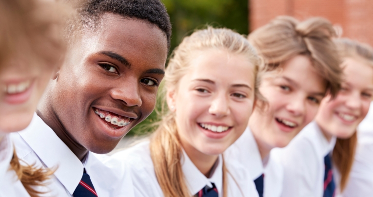 A group of smiling secondary school children