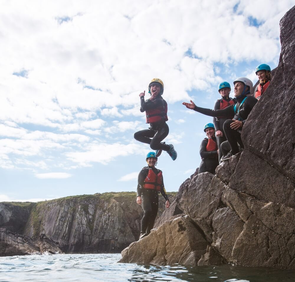 A primary school boy jumping into the sea