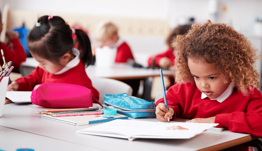 Children in class practising handwriting