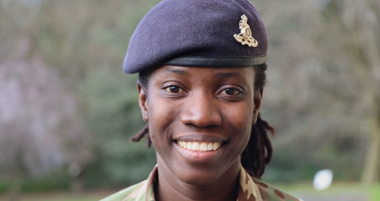 A woman in an army uniform smiling