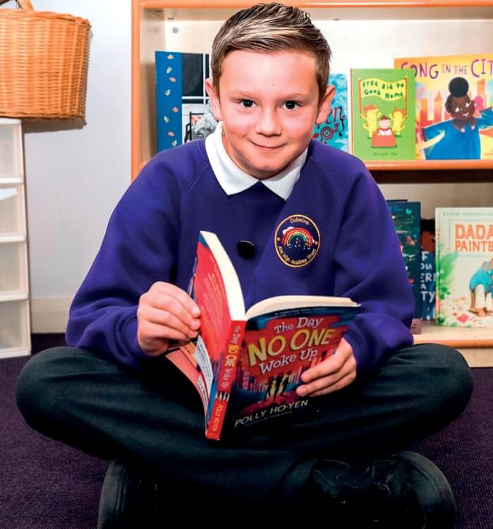 A schoolboy reading a book