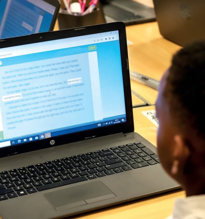 A schoolboy working on a laptop