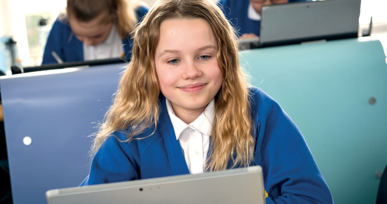 A primary school girl using a laptop