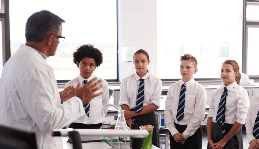 Man doing supply teaching in science lab with students looking at him