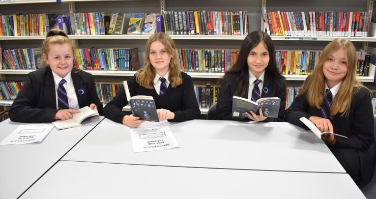 A group of secondary school girls sitting in a library