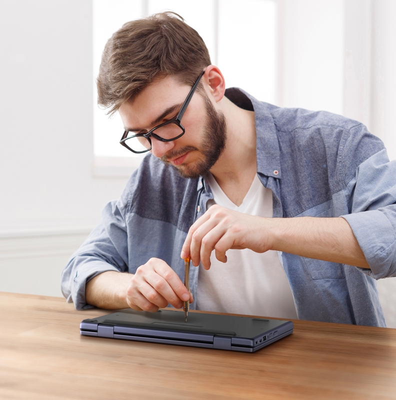 A man using a screwdriver to make repairs to a laptop