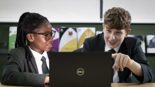 Two secondary school students looking at a laptop