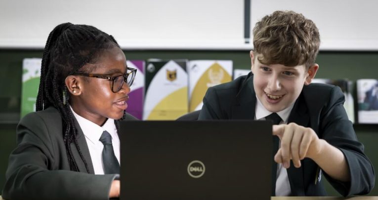 Two secondary school students looking at a laptop