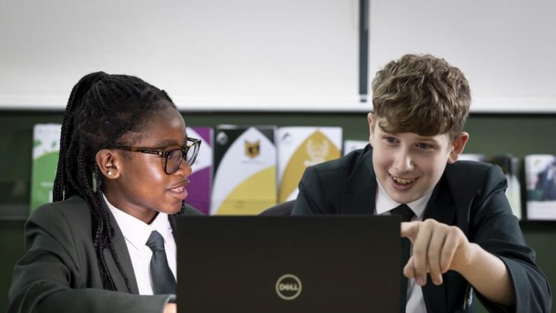 Two secondary school students looking at a laptop