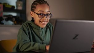 A school girl working at home on a laptop