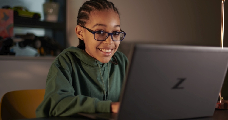 A school girl working at home on a laptop