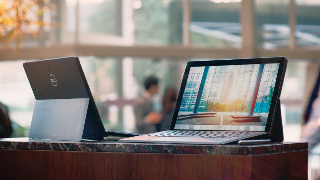 Two Dell laptops on a desk in a school