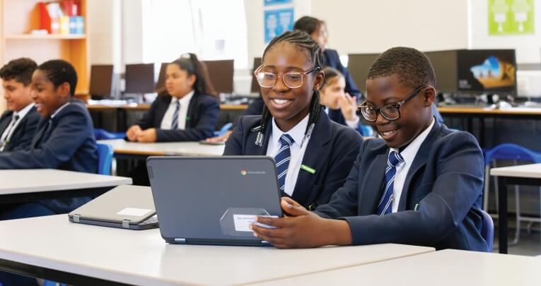 Two secondary school students working on a laptop