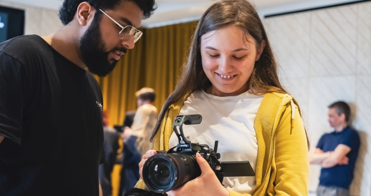 A secondary school girl holding a video camera