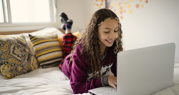 A secondary school girl looking at a laptop